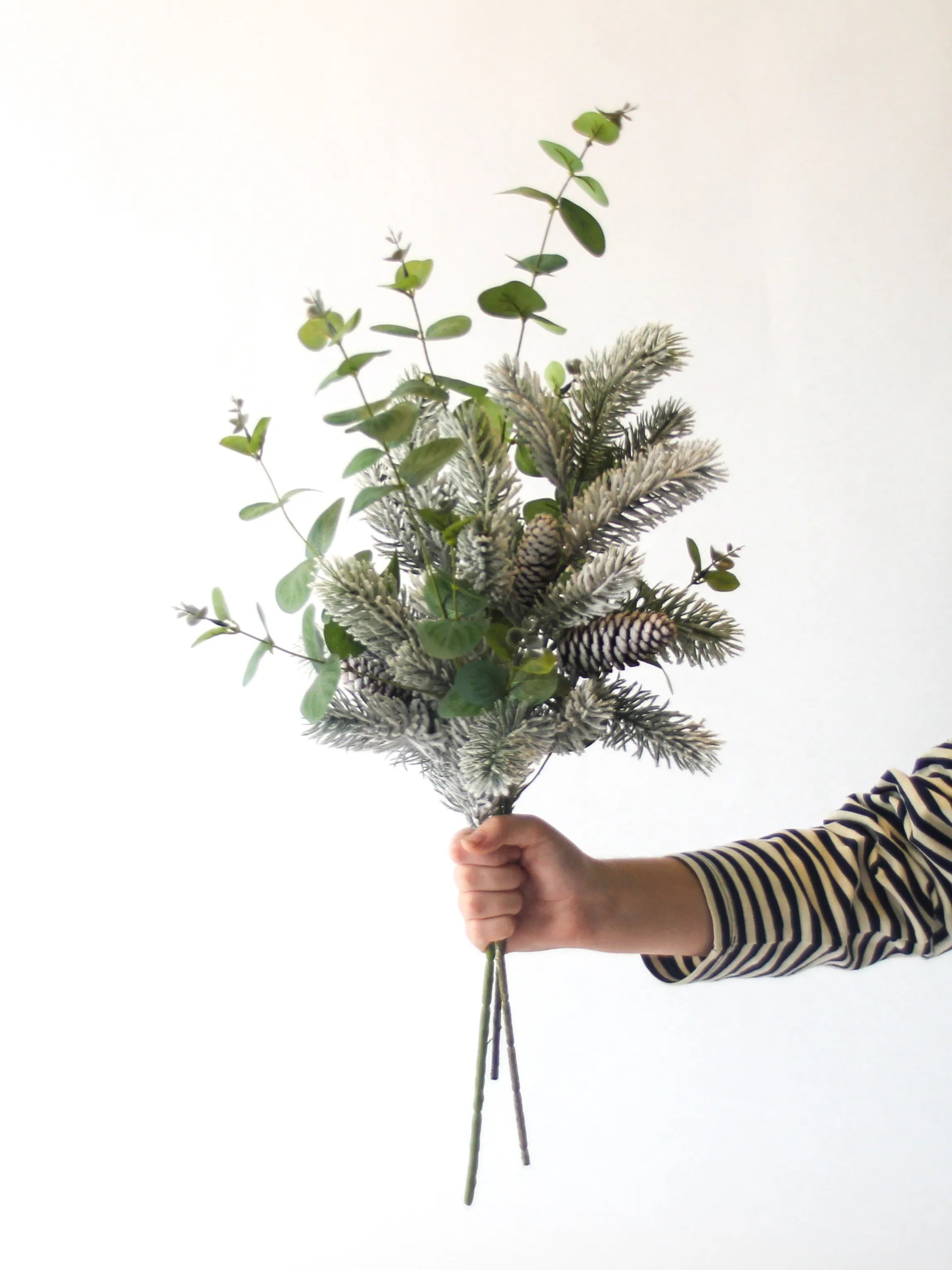 Zijden kerstboeket Silent Snow met besneeuwde Nordmann-tak en eucalyptus in witte candy vaas – 65 cm