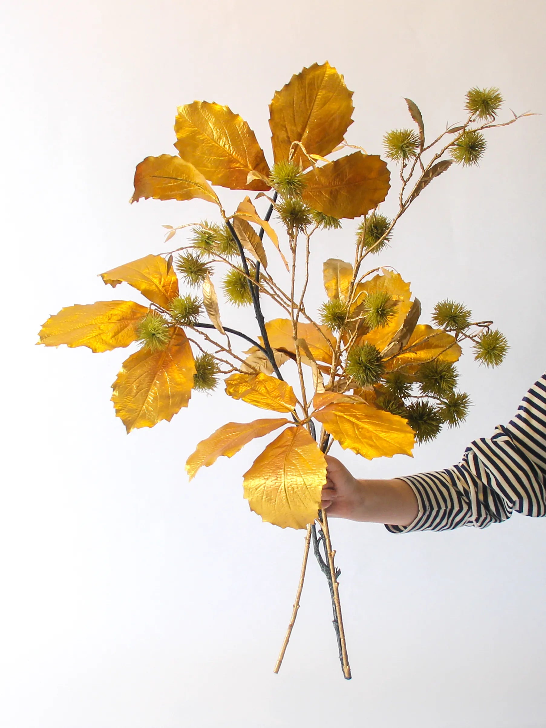 Zijden boeket Whisper met gouden bladeren en groene accenten in neutrale vaas – 90 cm hoog