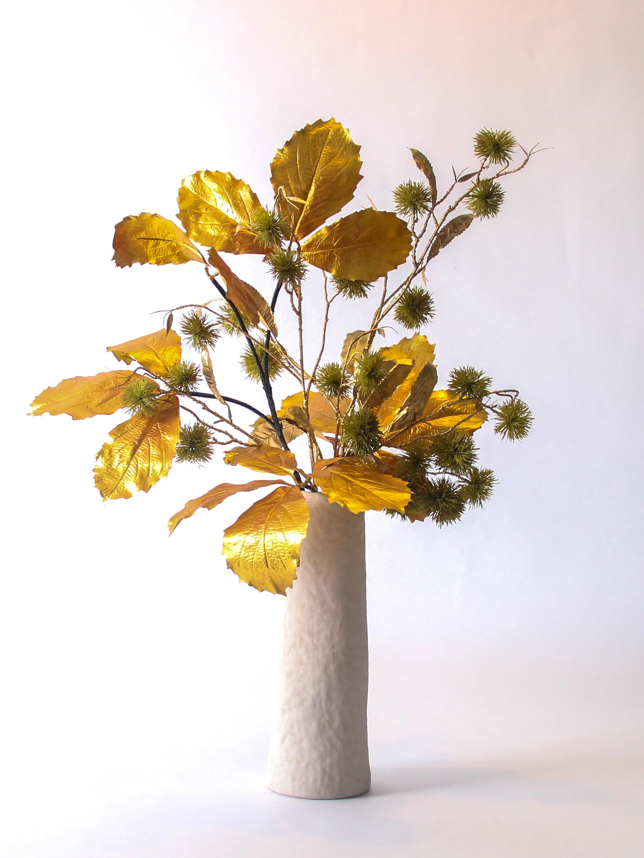 Zijden boeket Whisper met gouden bladeren en groene accenten in neutrale vaas – 90 cm hoog