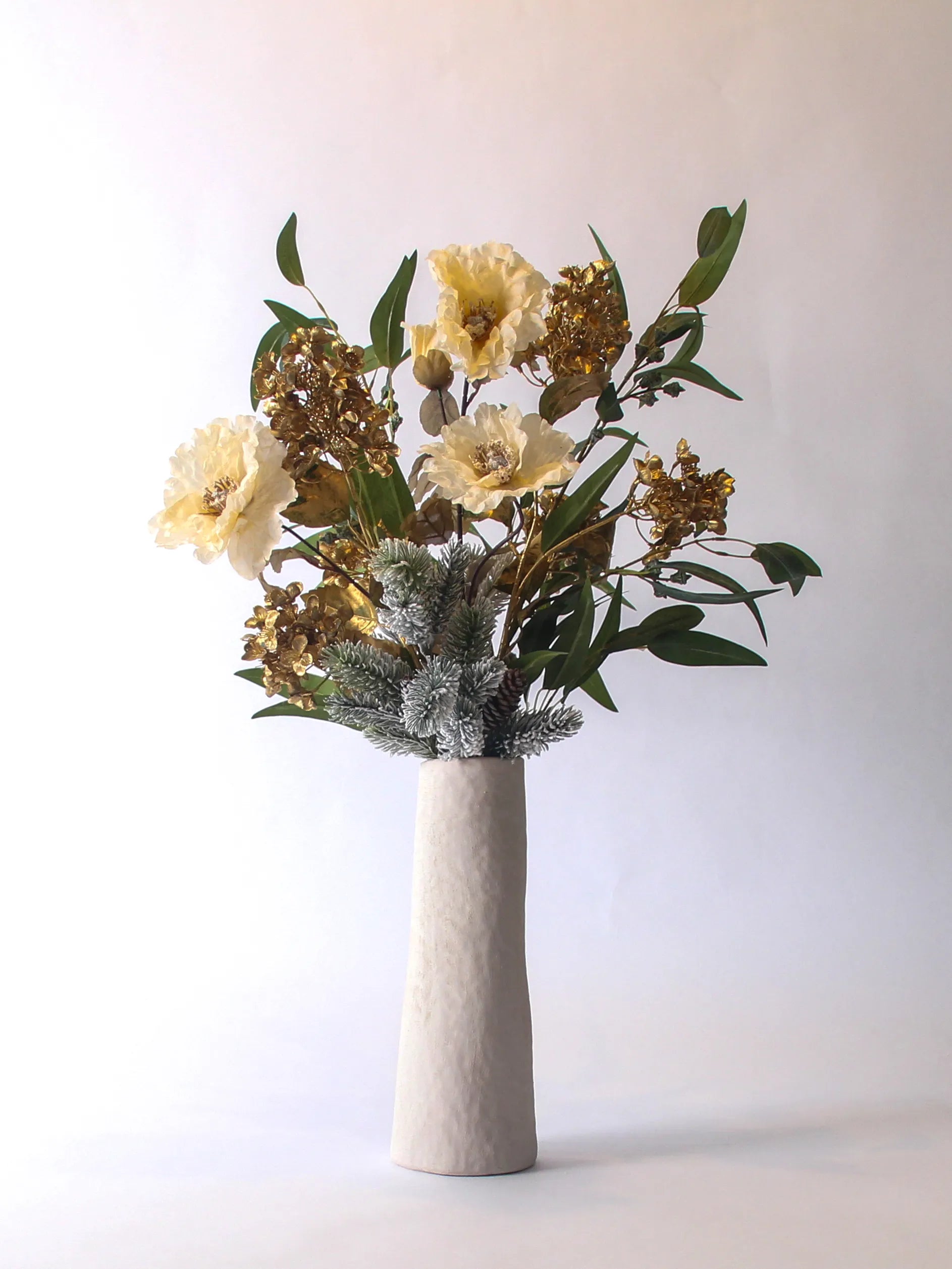 Winterboeket met gouden hydrangea, besneeuwde nordmann en groene bladeren in witte vaas – 75 cm hoog
